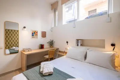a bedroom with a bed and a desk and a mirror at Pasalimani Seabreeze Apartment in Piraeus