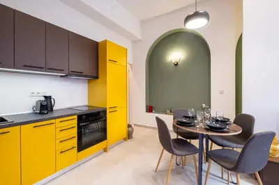 a kitchen with yellow cabinets and a table with chairs at Pasalimani Seabreeze Apartment in Piraeus