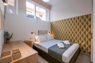 a small bedroom with a bed and a table at Pasalimani Seabreeze Apartment in Piraeus