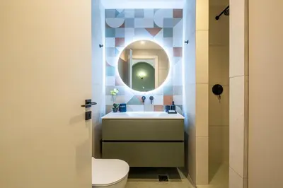 a bathroom with a toilet and a sink with a mirror at Pasalimani Seabreeze Apartment in Piraeus