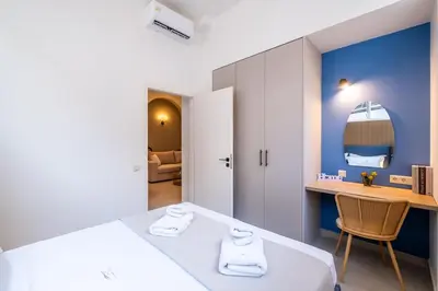 a bedroom with a bed and a desk in a room at Pasalimani Seaside Apartment in Piraeus