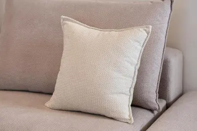 a white pillow sitting on a couch at Pasalimani Seaside Apartment in Piraeus