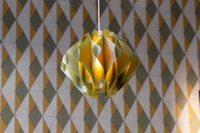 a yellow chandelier hanging from a wall with triangles at Pasalimani Seaside Apartment in Piraeus
