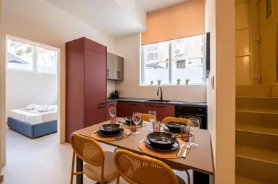 a kitchen with a table with wine glasses on it at Pasalimani Seaside Apartment in Piraeus