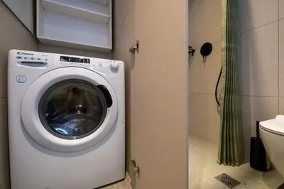 a washing machine in a bathroom next to a toilet at Pasalimani Seaside Apartment in Piraeus