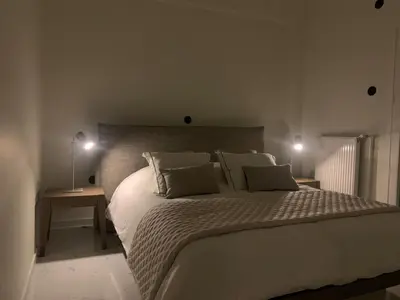 a bedroom with a large white bed with two lamps at Athens City apartment in Athens