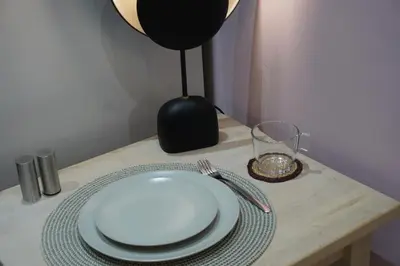 a table with a plate and fork and a glass at Athens City apartment in Athens
