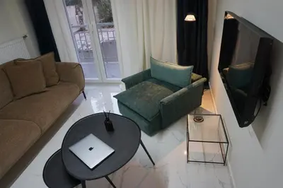 a living room with a couch and a table and a tv at Athens City apartment in Athens