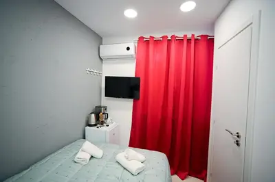 a bedroom with a red curtain and a bed with towels at Evagelistrias Monastiraki Suite by Zeussuites in Athens