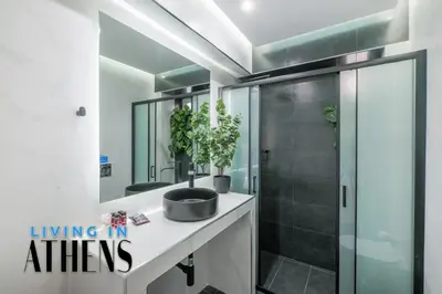 a bathroom with a sink and a shower with a mirror at Athenian Exclusive residence 2&2 ppl in Athens
