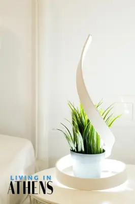 a plant in a white pot on a table next to a window at Athenian Exclusive residence 2&2 ppl in Athens