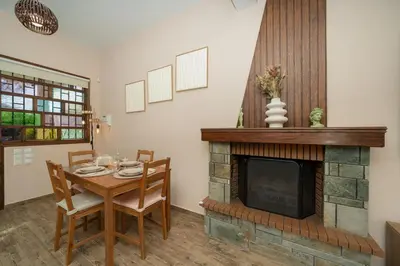 a dining room with a table and a fireplace at Olivea Residence by A&D Properties in Porto Rafti