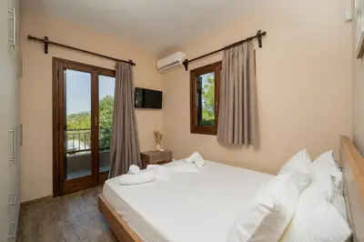 a bedroom with a white bed and a window at Olivea Residence by A&D Properties in Porto Rafti