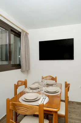 a dining room table with plates and wine glasses at Olivea Residence by A&D Properties in Porto Rafti