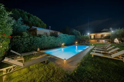 a swimming pool in a yard at night at Olivea Residence by A&D Properties in Porto Rafti