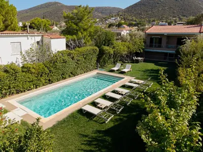 an image of a swimming pool with chairs and a house at Olivea Residence by A&D Properties in Porto Rafti