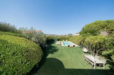 a garden with a swimming pool and a hedge at Olivea Residence by A&D Properties in Porto Rafti