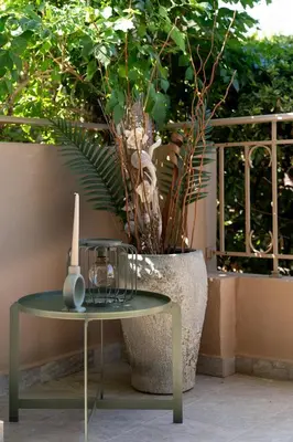 a table sitting next to a vase with a plant at Olivea Residence by A&D Properties in Porto Rafti