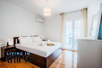 a white bedroom with a bed and a balcony at Comfortable & Modern Apt 4floor 3ppl in Piraeus