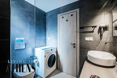 a bathroom with a washing machine and a sink at Comfortable & Modern Apt 4floor 3ppl in Piraeus