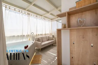 a bathroom with a tub in a room with a couch at Breathtaking View Studio With Jacuzzi 2ppl 6th flr in Athens