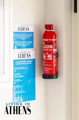 a red fire extinguisher and a sign on a wall at Breathtaking View Studio With Jacuzzi 2ppl 6th flr in Athens
