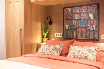 a bedroom with a bed with orange sheets and pillows at Crown Design Apt - Acropolis in Athens