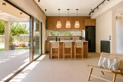 an open kitchen with a island and chairs in a house at The Attican Villa & Estate in Anavissos