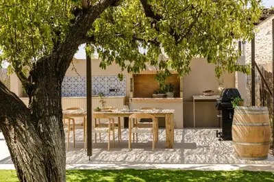 a patio with a table and chairs under a tree at The Attican Villa & Estate in Anavissos