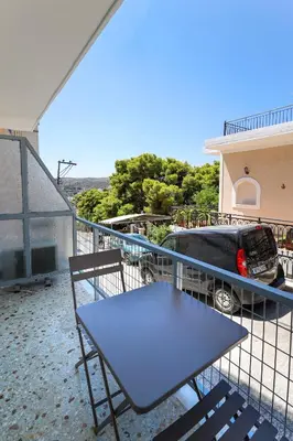 a table and chairs on a balcony with a truck at Muse Studios & Apartments Aegina in Agia Marina Aegina