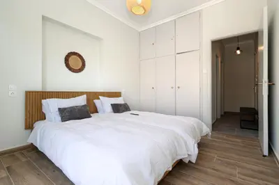 a bedroom with a large white bed with white cabinets at Muse Studios & Apartments Aegina in Agia Marina Aegina