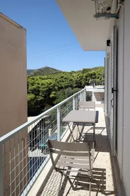 a table and chairs on a balcony with a view at Muse Studios & Apartments Agia Marina in Agia Marina Aegina