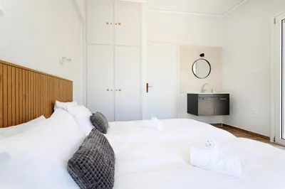 a bedroom with a large white bed with two pillows at Muse Studios & Apartments Agia Marina in Agia Marina Aegina