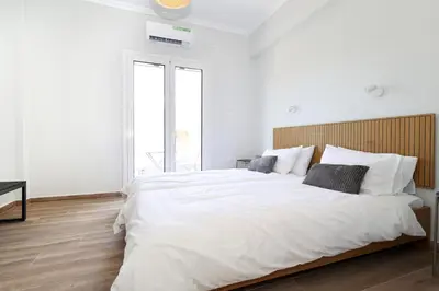 a white bedroom with a large white bed with pillows at Muse Studios & Apartments Escape in Agia Marina Aegina
