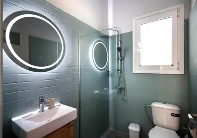 a bathroom with a sink and a glass shower at Muse Studios & Apartments Escape in Agia Marina Aegina