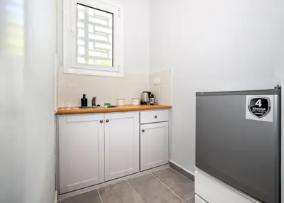 a kitchen with a sink and a refrigerator at Muse Studios & Apartments Escape in Agia Marina Aegina