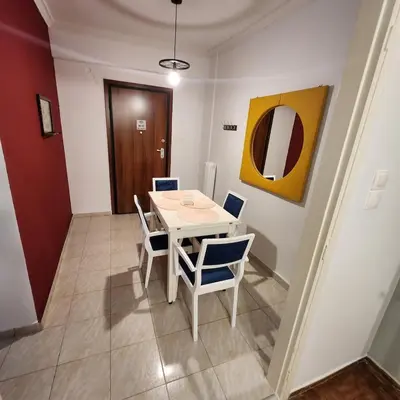 a dining room with a white table and chairs at Athens Nest two in Athens