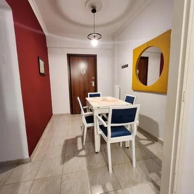 a dining room with a white table and chairs at Athens Nest two in Athens