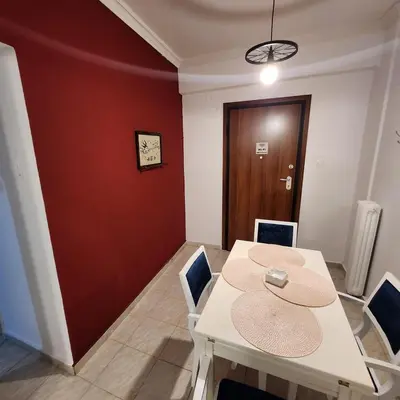 a dining room with a white table and chairs at Athens Nest two in Athens