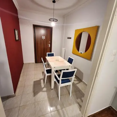 a dining room with a white table and chairs at Athens Nest two in Athens