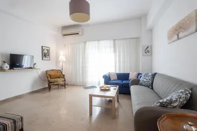 a living room with a blue couch and a table at Comfort Apartment with 2 Bedrooms in Athens