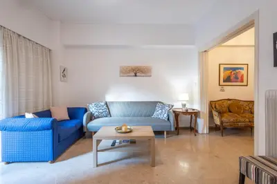a living room with a blue couch and a table at Comfort Apartment with 2 Bedrooms in Athens