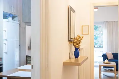 a room with a table and a vase with flowers in it at Comfort Apartment with 2 Bedrooms in Athens