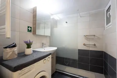 a bathroom with a sink and a washing machine at Comfort Apartment with 2 Bedrooms in Athens
