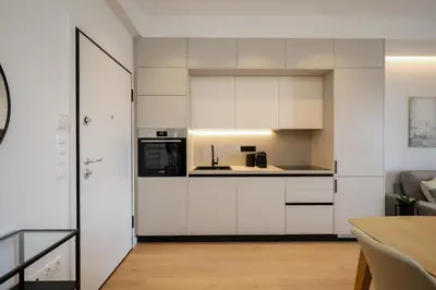 a kitchen with white cabinets and a counter top at Piraeus Riviera Residence in Piraeus