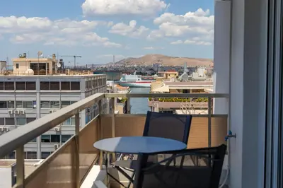 a balcony with a table and a view of the water at Piraeus Riviera Residence in Piraeus