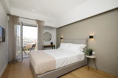 a bedroom with a large bed and a balcony at Piraeus Riviera Residence in Piraeus