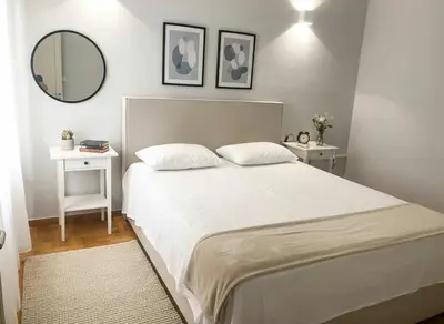 a bedroom with a large white bed and a mirror at Bright 2-Bedroom Apt in Ampelokipoi Near Hospital in Athens