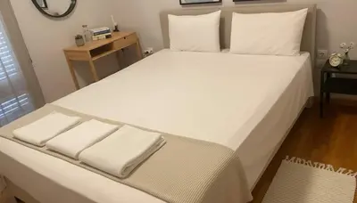 a large bed with white sheets and pillows on it at Bright 2-Bedroom Apt in Ampelokipoi Near Hospital in Athens