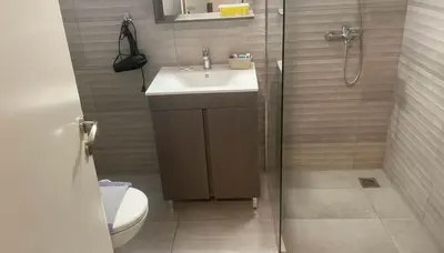 a bathroom with a sink and a shower at Bright 2-Bedroom Apt in Ampelokipoi Near Hospital in Athens